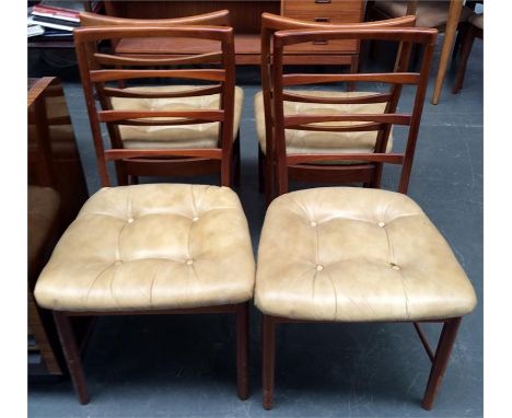 A set of four McIntosh teak ladder back dining chairs with cream leatherette seats