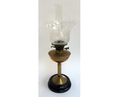 A 19th century oil lamp with brass column and reservoir, raised on a black ceramic base, 'Best British Make', with glass and 