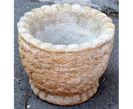 A composite stone circular planter featuring oak leaves and acorns