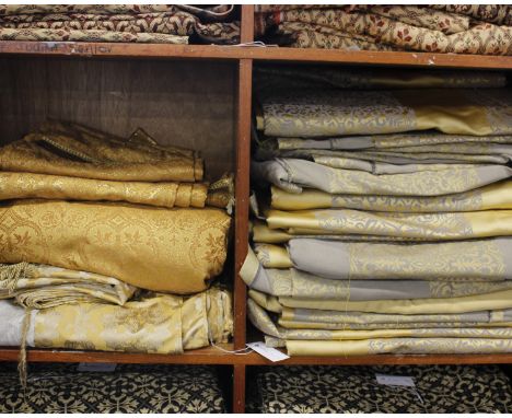 A large quantity of gold pattered fabric including pale gold and grey patterned panels and large sections for use for curtain