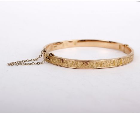 A 9ct gold hollow bangle, the hinged bangle with chased ivy leaf decoration, stamped 375 with full Chester hallmarks, 6cm wid