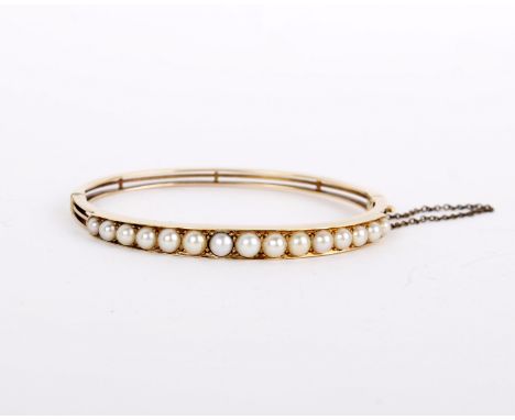 A gold coloured cultured pearl bangle, the hinged bangle set with cultured pearls, 5.7cm wide, 14.3g