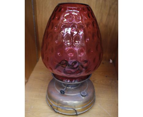 An Antique Metal Based Oil Lamp with Cranberry Glass Shade 43 cm high
