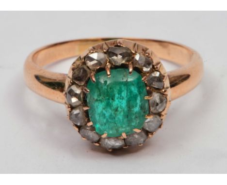 Unmarked ring set with central cabochon emerald surrounded by diamonds