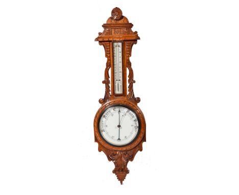 Late Victorian oak wheel barometer with carved decoration and enamel dials, incorporating a further temperature guage