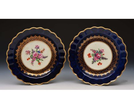 Pair of Worcester blue ground plates circa 1768, with scalloped edges, decorated in enamels and gilding with European flowers