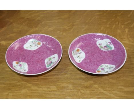 Pair of Chinese famille rose saucers decorated with three floral reserves on a graviata worked pink ground, each with Guangxu