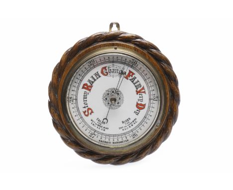 AN EARLY 20TH CENTURY ANEROID BAROMETERin circular oak mount, with twisted rope edge, and enamel face, 24cm diameter
