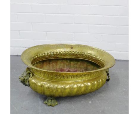 An oval brass planter with hairy paw brass feet and lion mask handles to side, (a/f) 