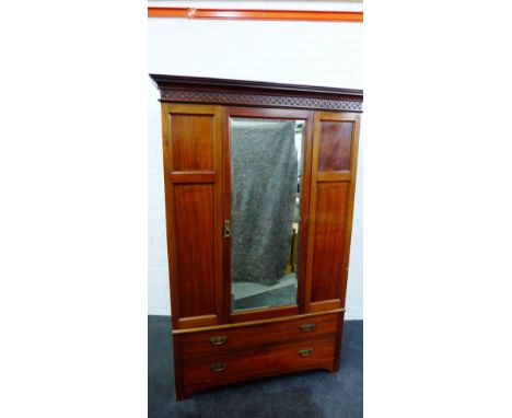 A mahogany wardrobe, the cornice top over a carved frieze and central mirror door above two long drawers, 208 x 132cm 