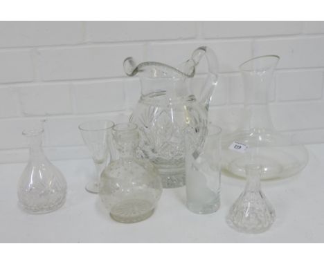 A cut glass water jug, together with a modern glass carafe, together with an etched glass jug, a contemporary art glass etche