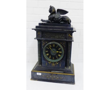 A Victorian black slate mantle clock surmounted by a bronzed metal Sphinx above a chariot race frieze over the circular dial 