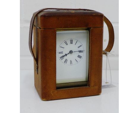A brass cased carriage clock, the enamel dial with Roman numerals, complete with its outer carrying case and key, height incl