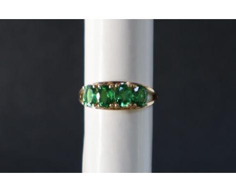 Gemporia - A 9ct gold Tsavorite garnet ring, set with oval cut garnets to a 9ct gold setting and shank, size L to M 