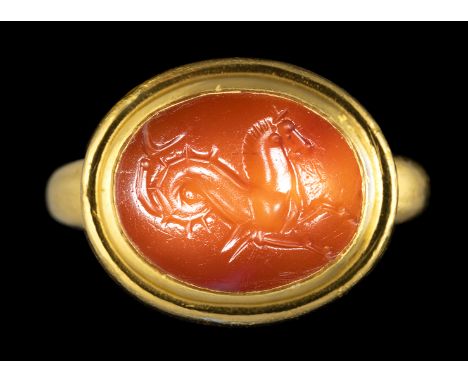 A GREEK CARNELIAN INTAGLIO SET IN A MODERN GOLD RING. SEAHORSE. 5th - 4th century B.C. Stone 14x18 mm; int. size 18x22 mm; 22