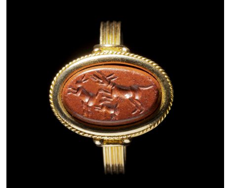 A ROMAN RED JASPER INTAGLIO SET IN A GOLD RING. HUNTING SCENE. 2nd-3rd century A.D.Stone 8x13 mm; int. Size 18x19 mm; 6,48 gr