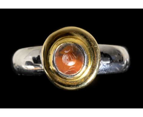 AN ITALIC CARNELIAN INTAGLIO SET IN A MODERN BICOLOR GOLD RING. POMEGRENATE. 2nd - 1st century B.C. Stone 5,5x6,5 mm; int. di