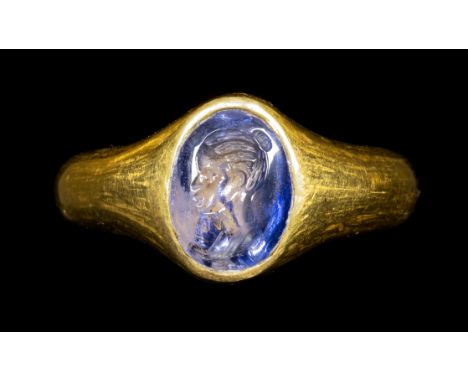 A RARE ROMAN GOLD RING SET WITH A SAPPHIRE INTAGLIO. PORTRAIT OF A NUBIAN NOBLEWOMAN. 2nd century A.D.Stone 8x11 mm; int. dia