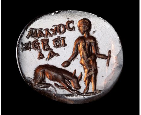 A ROMAN GARNET INTAGLIO. YOUNG SHEPHERD WITH HIS DOG AND GREEK INSCRIPTIONS. 3rd century A.D. 11x13x2 mm The young draped cha