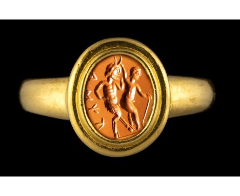 A ROMAN RED JASPER INTAGLIO SET IN A MODERN GOLD RING. EROTIC SCENE WITH INSCRIPTION. 1st-2nd century A.D.Stone 9x11 mm; int.