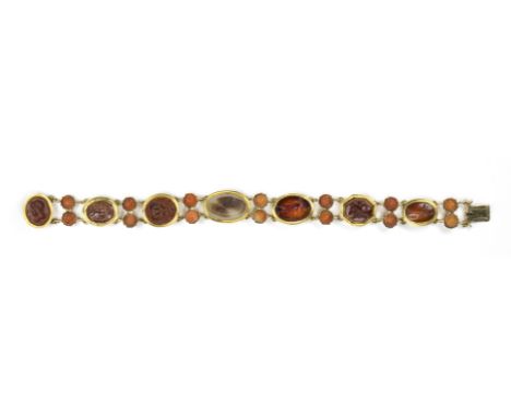 A VICTORIAN GOLD BRACELET WITH SEVEN ROMAN HARDSTONES INTAGLIOS AND CORAL ROSES. VARIOUS SUBJECTS. Stones: 2nd-3rd century A.