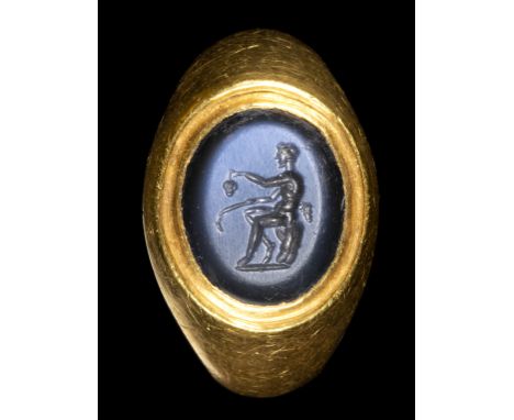 A ROMAN NICOLO INTAGLIO SET IN A GOLD RING. SEATED SATYR WITH ATTRIBUTES. 1st - 2nd century A.D.Stone 10x13 mm; int. Size 18x