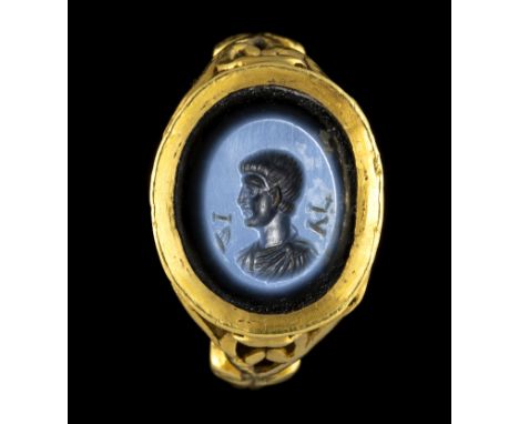 A LATE ROMAN NICOLO INTAGLIO SET IN A OPENWORK GOLD RING. MALE PORTRAIT WITH INITIALS. Late 3rd- Early 4th century A.D.Stone 