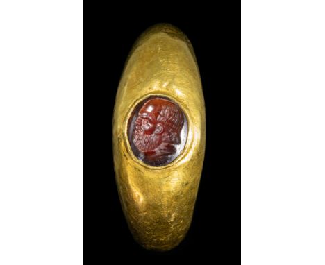 A ROMAN GOLD RING WITH A GARNET INTAGLIO. SOCRATES PORTRAIT. 1st-2nd century A.D.Stone 6x8 mm; int. Size 16x18 mm; 3,30 grWit