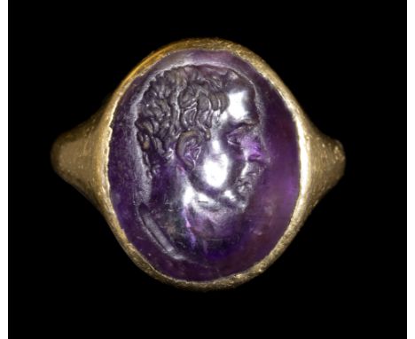 A ROMAN AMETHYST INTAGLIO SET IN A GOLD RING. MALE PORTRAIT. 1st century A.D.Stone 11x14 mm; int. diam 13 mm; 6,69 gr.Portrai