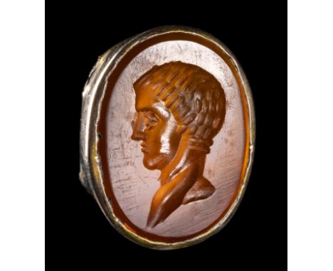 A ROMAN CARNELIAN INTAGLIO SET IN A GOLD FRAME. MALE PORTRAIT.1st - 3rd century A.D.9 x 12 x 4 mm. Male portrait of a young m