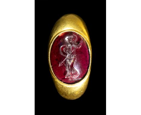 A GREEK LATE HELLENISTIC GARNET INTAGLIO SET IN A GOLD RING. ATHENA. 2nd-1st century B.C. Stone 11x15 mm; int.diam 16 mm; 10,