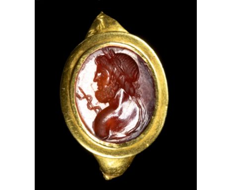 A ROMAN FRAGMENTARY GOLD RING SET WITH A CARNELIAN INTAGLIO. BUST OF ASCLEPIOS. 1st-2nd century A.D.Stone 13x15 mm; 2,24 grTh