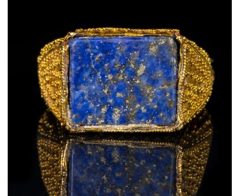 A LARGE FATIMID GOLD GRANULATED RING WITH A RECTANGULAR BEZEL TABLE SET WITH A LAPIS LAZULI. 10th-12th century A.D.Stone 11x1