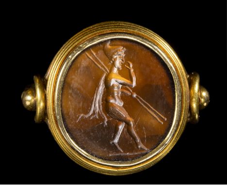 A FINE LATE ROMAN REPUBLICAN SARD INTAGLIO SET IN A GOLD RING. ATTIS WITH TWO SPEARS. 1st century B.C.Stone diam. 15 mm; int.