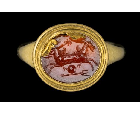 A ROMAN CARNELIAN INTAGLIO SET IN A MODERN GOLD RING. ALLEGORICAL EMBLEMA WITH TWO SEAGOATS. 1st century A.D.Stone 10x12 mm; 