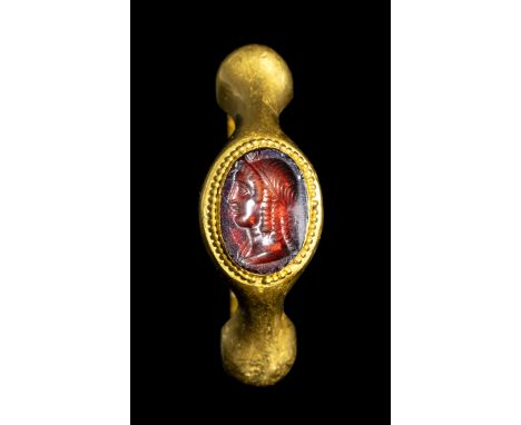 A FINE GREEK PTOLEMAIC GARNET INTAGLIO SET IN A LATER GOLD RING. BUST OF ISIS. Stone 3rd - 2nd century B.C. Ring 3rd century 