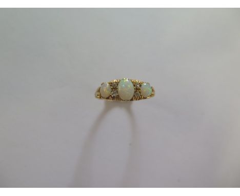 An 18ct hallmarked yellow gold three stone opal and diamond ring size R - approx weight 4.7 grams - good condition 