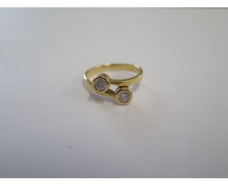 An 18ct yellow gold two stone diamond crossover ring size L - approx weight 3.6 grams - in good condition, small usage marks 