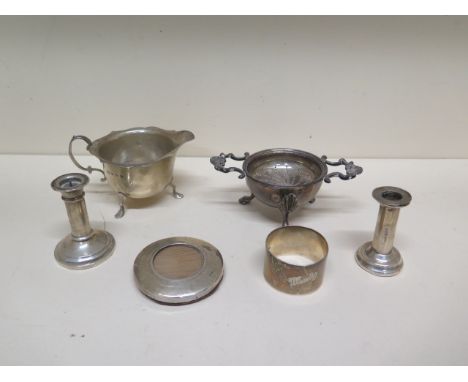 A silver cream jug, strainer and base, napkin ring, part frame and two miniature candlesticks - weighable silver approx 9.3 t