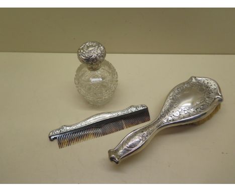 A sterling silver brush, comb and a white metal top scent bottle 