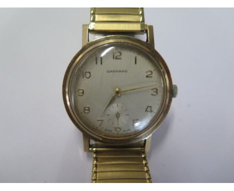 A 9ct yellow gold manual wind Garrard presentation wristwatch on a plated strap - 33mm case - total weight approx 54 grams - 