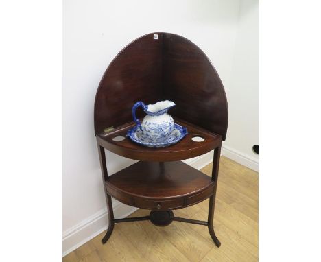 A Georgian mahogany corner washstand with a folding gallery top and base drawer with a modern blue and white jug and basin - 