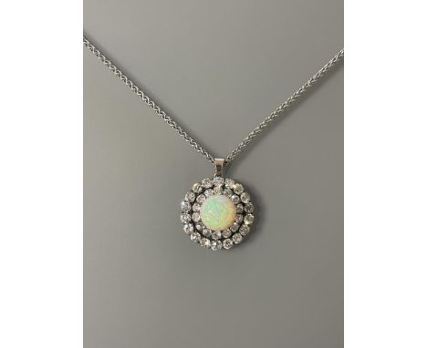 A stunning Opal and Diamond pendant/brooch 28.5mm diameter with a centre cabochon Opal approx 13.5mm x 7mm, surrounded by two