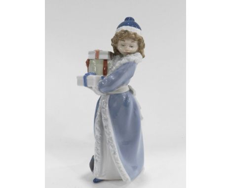 A Nao by Lladro figure, of a girl in flowing robes holding Christmas presents, marked beneath, 23cm high.  (boxed)