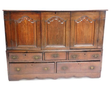 An 18thC oak mule chest, the planked top with a moulded edge, above two panelled doors flanking a central fixed panel, with a