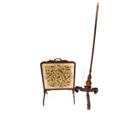 An early Victorian mahogany pole screen, with twisted and turned column and carved tripod base and a firescreen inset with a 