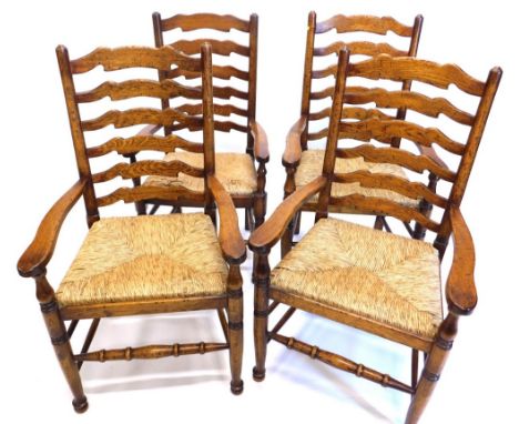 Two pairs of Brights of Nettlebed oak ladder back chairs, each with a rush seat, on turned legs with stretchers.