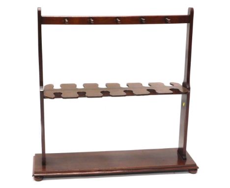 A 19thC mahogany whip or umbrella stand, with turned legs, shaped recesses on tapering end supports, above a moulded platform