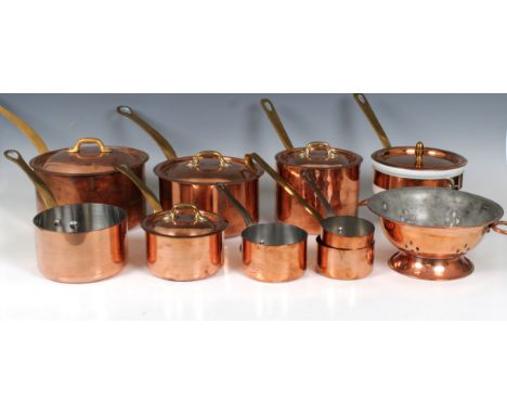 A collection of French copper and brass tin lined panscomprising four graduated lidded saucepans and three smaller saucepans 