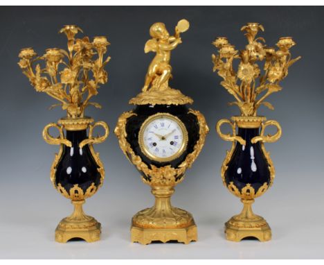 A 19th century French ormolu and blue porcelain clock garniture by Raingo Freres Paristhe deep blue urn form body with gilt m